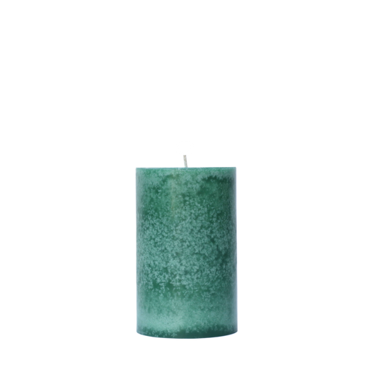 A single handcrafted pillar candle featuring a mottled wax finish with a distinct snowflake-like pattern in a solid winter green hue.