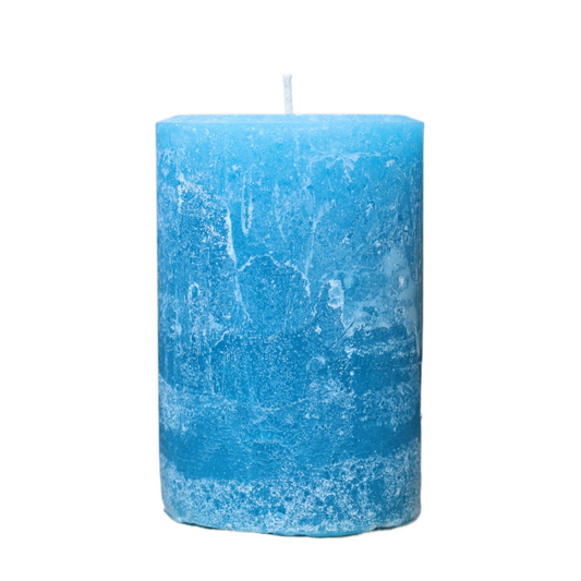 A handcrafted bright lake blue pillar candle with a 'Petrified' rustic texture, showing a weathered, frosted, stone-like finish in muted earth tones. 
