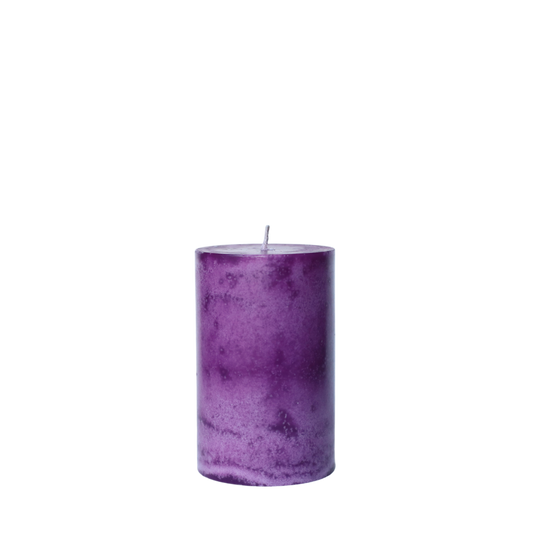 A single handcrafted pillar candle featuring a mottled wax finish with a distinct snowflake-like pattern in a solid purple hue.