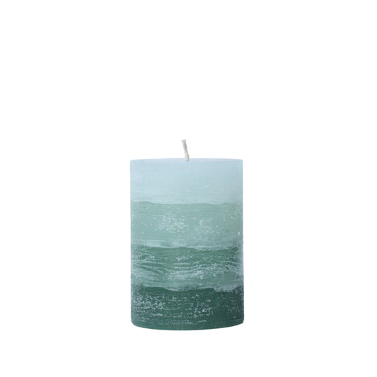 A solid-color gradation pillar candle with four distinct layers of sage green, featuring a textured, weathered surface for a Nordic-inspired look.