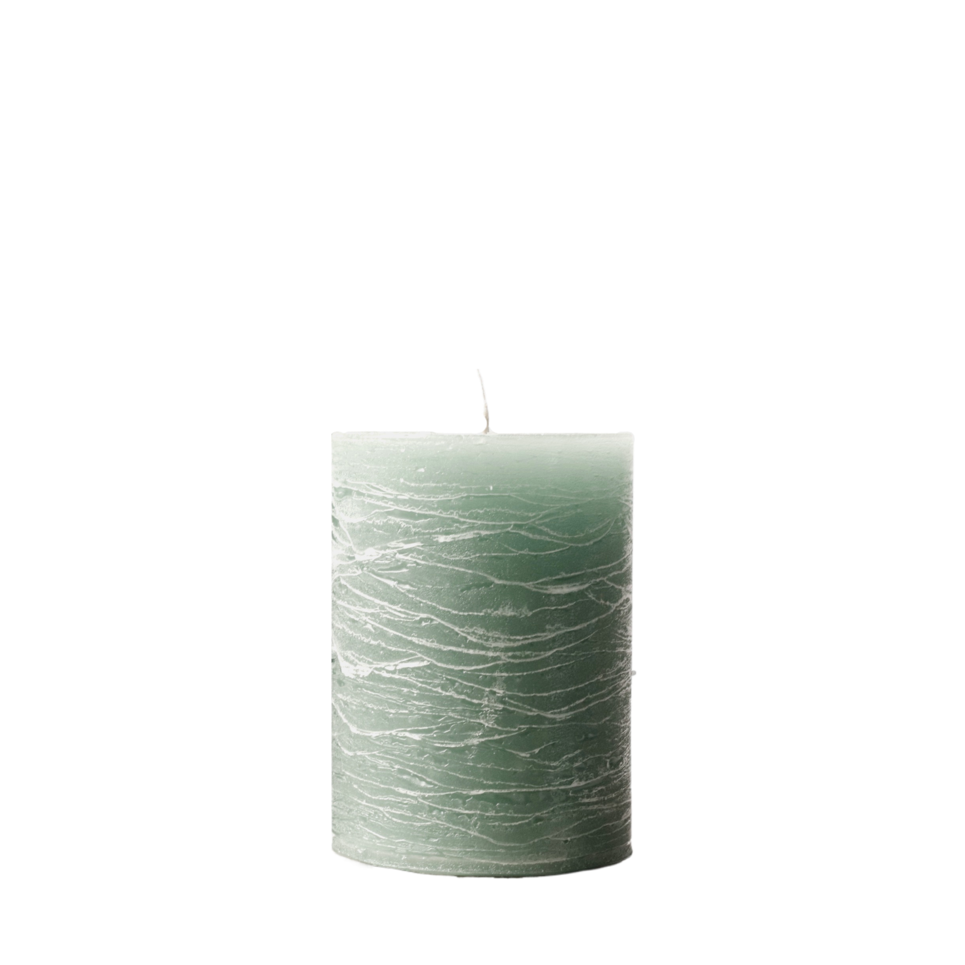 A minimalist Nordic-style pillar candle in a solid muted sage green, featuring horizontal textured lines and a handcrafted rustic finish.