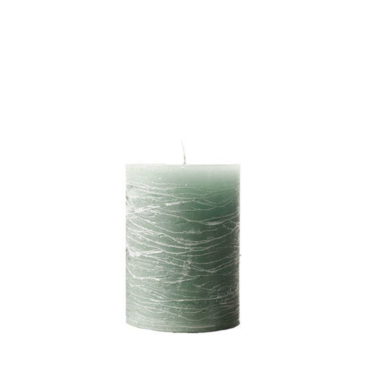 A minimalist Nordic-style pillar candle in a solid muted sage green, featuring horizontal textured lines and a handcrafted rustic finish.