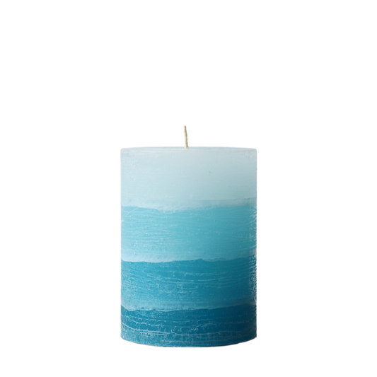 A solid-color gradation pillar candle with four distinct layers of teal blue, featuring a textured, weathered surface for a Nordic-inspired look.