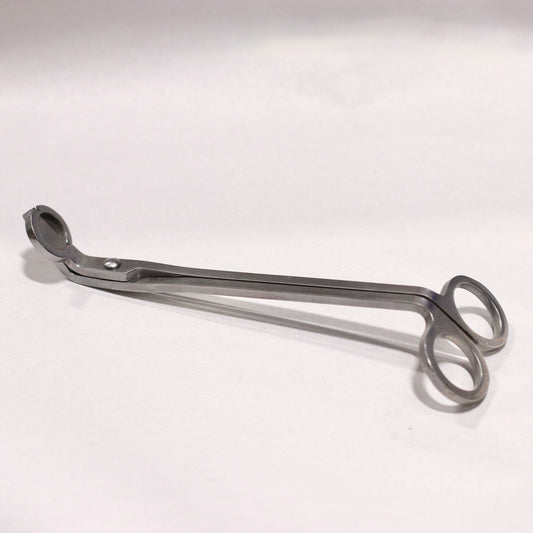 A metal wick trimmer on a white background.